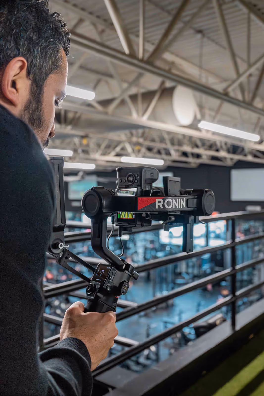 A Perseus videographer operates a DJI Ronin gimbal above a gym floor, capturing cinematic fitness content for a brand.