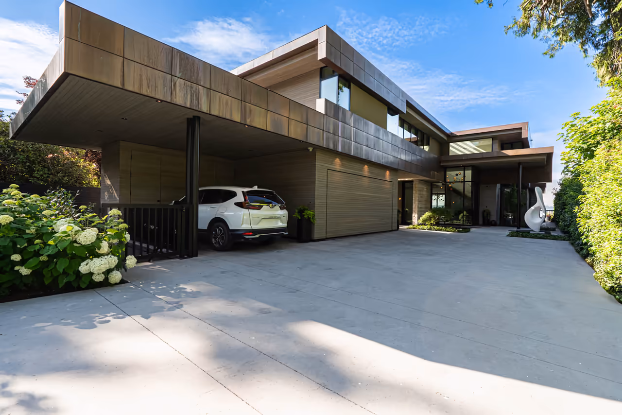 Modern wood-clad West Vancouver home with a covered carport and sculpted landscaping at 2870 Bellevue Ave, captured for CityScape Electrical by Perseus Creative Studio.