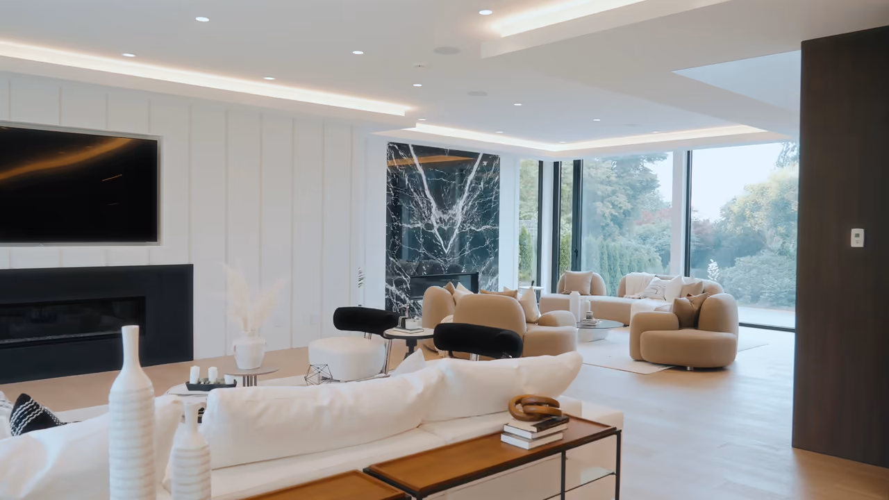 Bright modern living room with a black marble fireplace and floor-to-ceiling windows in a North Vancouver home, filmed for Diba Windows by Perseus Creative Studio.