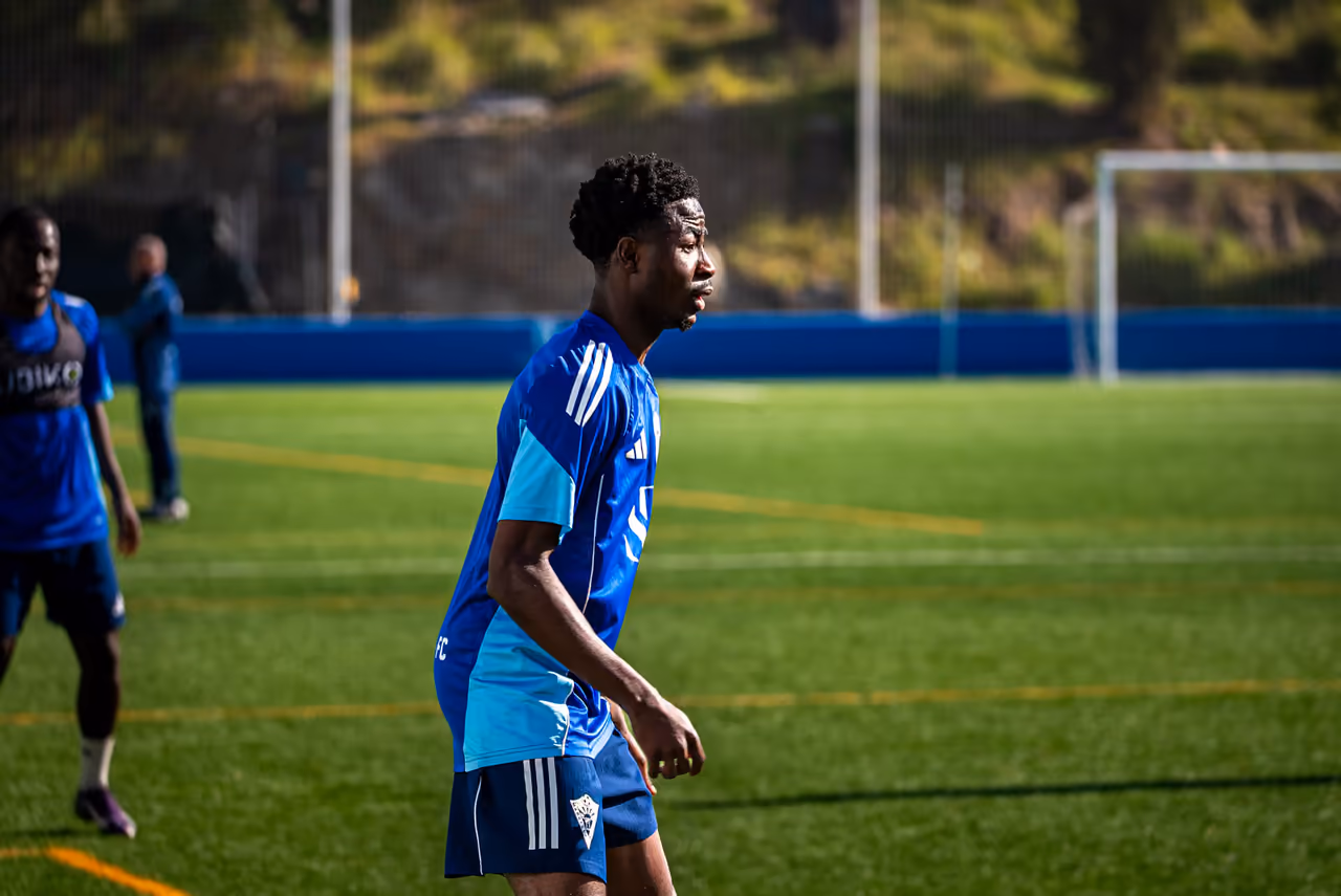 Match Tour 11 footballer Andy Owusu in a blue training kit on the pitch during a session, photographed by Perseus Creative Studio.