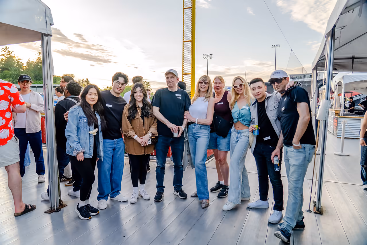 Guests wearing name tags gathered on an outdoor stadium deck at sunset during the Faith Wilson Group client appreciation event, photographed by Perseus Creative Studio.