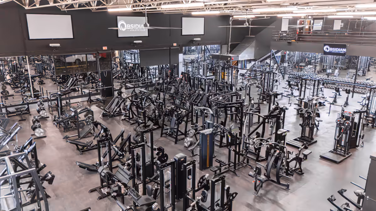 Wide interior of Obsidian Athletic Club’s North Vancouver gym floor packed with strength equipment, photographed by Perseus Creative Studio.