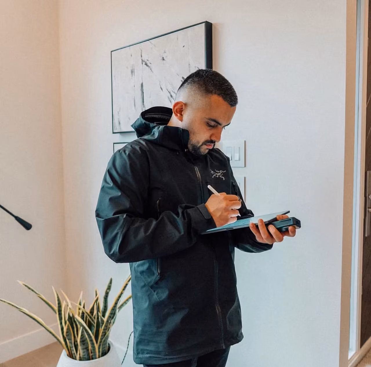 Perseus Creative Studio specialist measuring an interior on a tablet to produce a 2D floor plan and 3D model of the space.